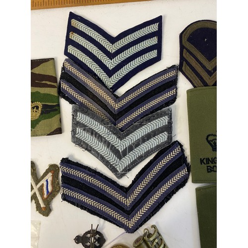 517 - Collection of military cap badges and patches.