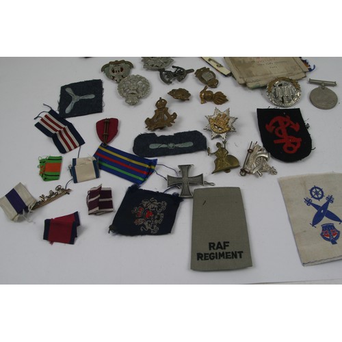44 - Collection of Military cap badges, patches, ribbons and WW2 medal