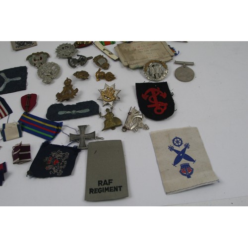 44 - Collection of Military cap badges, patches, ribbons and WW2 medal