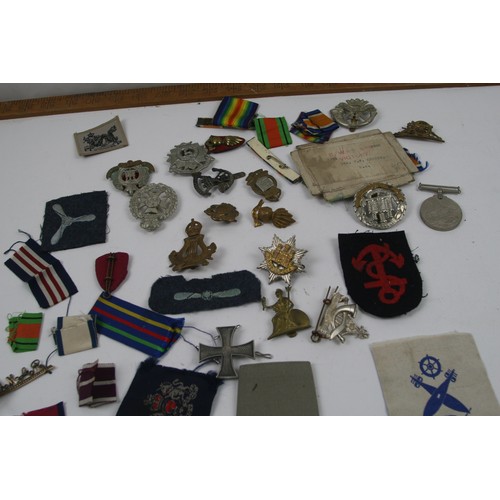 44 - Collection of Military cap badges, patches, ribbons and WW2 medal