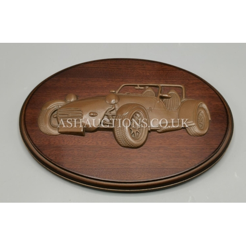 82 - HAND CRAFTED SCULPTURE OF A MORGAN PLUS 4  MOUNTED ON A WOODEN OVAL 23cm x 16.5cm PLAQUE By Linda We... 