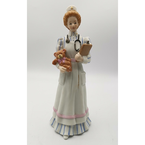 65 - ENESCO 19cm PORCELAIN CHARACTER FIGURINE OF A NURSE CARRYING A TEDDY BEAR.