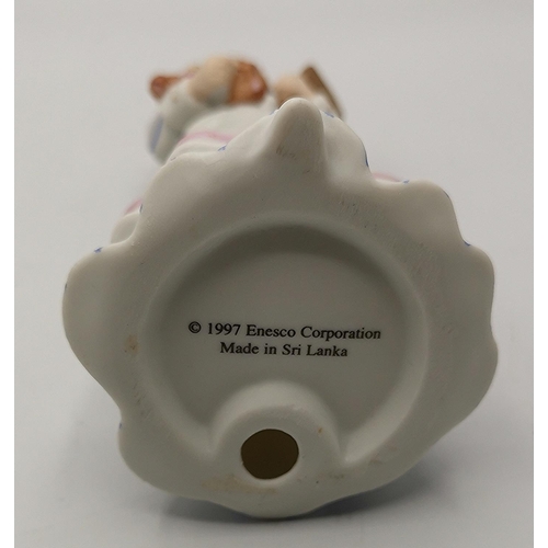 65 - ENESCO 19cm PORCELAIN CHARACTER FIGURINE OF A NURSE CARRYING A TEDDY BEAR.