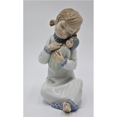 714 - LLADRO (Nao) PORCELAIN 15.5cm CHARACTER FIGURINE OF A YOUNG GIRL HOLDING A DOLL (Model No 5102) (Ret... 