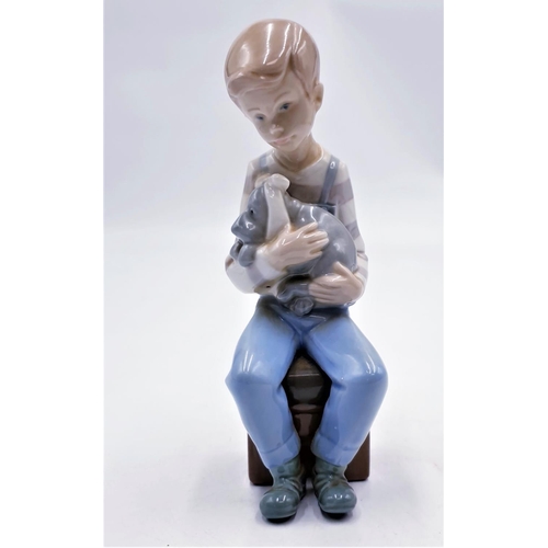 673 - LLADRO (Nao) PORCELAIN 17cm CHARACTER FIGURINE OF A BOY SAT ON A STOOL IN HIS ARMS RESTS A POORLY PU... 