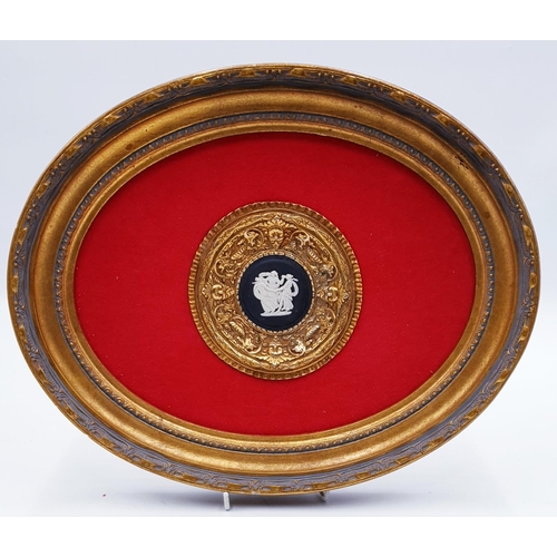 746 - WEDGWOOD BLACK JASPER WARE PLAQUE MOUNTED IN A 36cm x 29cm OVAL GOLD FRAME.
(Please Note This Lot WI... 