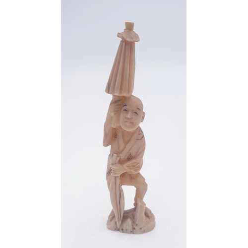 297 - ORIENTAL 12cm FIGURINE OF A MAN WITH PARASOL