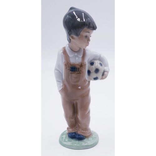 767 - LLADRO (Nao) 18.5cm PORCELAIN CHARACTER FIGURINE OF A YOUNG BOY HOLDING A FOOTBALL 