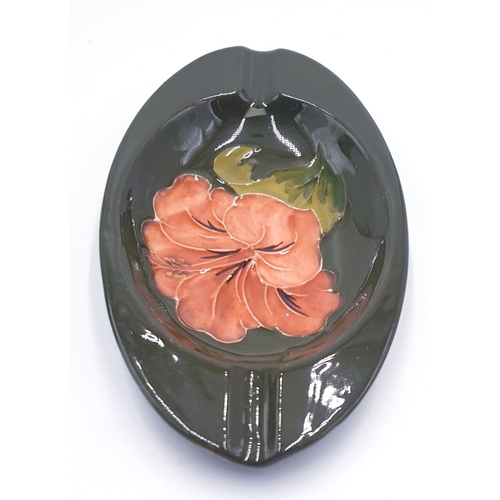 783 - MOORCROFT OVAL ASHTRAY IN THE HIBISCUS DESIGN ON THE DARK GREEN GROUND