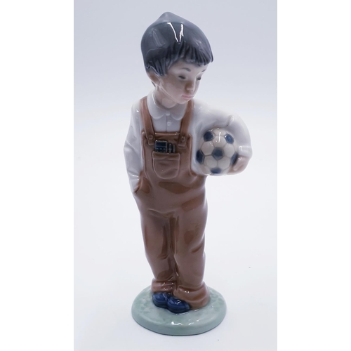 916 - LLADRO (Nao) 18.5cm PORCELAIN CHARACTER FIGURINE OF A YOUNG BOY HOLDING A FOOTBALL 