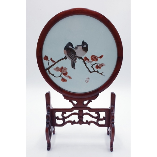 166 - ORIENTAL SILK EMBROIDARY OF A BIRD ON A 35cm x 18cm SWIVEL STAND