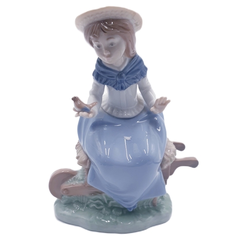 223 - LLADRO (Nao) PORCELAIN 17.5cm CHARACTER FIGURINE OF A YOUNG SAT ON A WHEELBARROW 