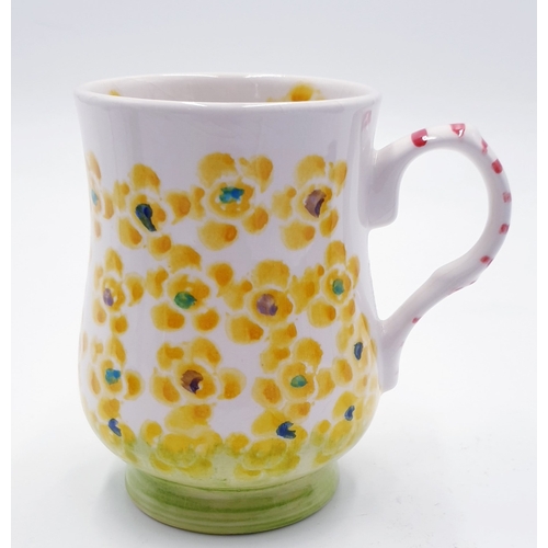 550 - ANITA HARRIS ART POTTERY MUG IN A FLORAL DESIGN