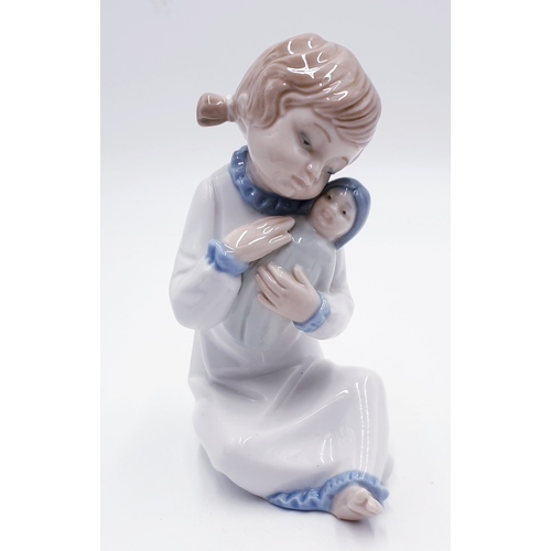 291 - LLADRO (Nao) PORCELAIN 15.5 cm CHARACTER FIGURINE OF A YOUNG GIRL HOLDING HER DOLL 