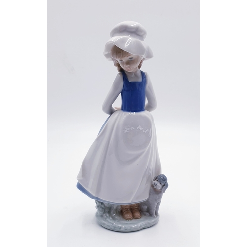 300 - LLADRO (Nao) PORCELAIN 23.5cm CHARACTER FIGURINE OF A YOUNG GIRL WITH ARMS BEHIND HER BACK AND PUPPY... 