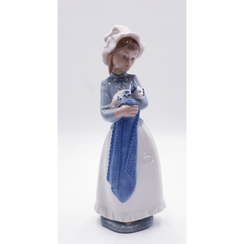 307 - LLADRO (Nao) PORCELAIN 25cm CHARACTER FIGURINE OF A YOUNG GIRL WEARING A BONNET AND IN A BLANKET SHE... 