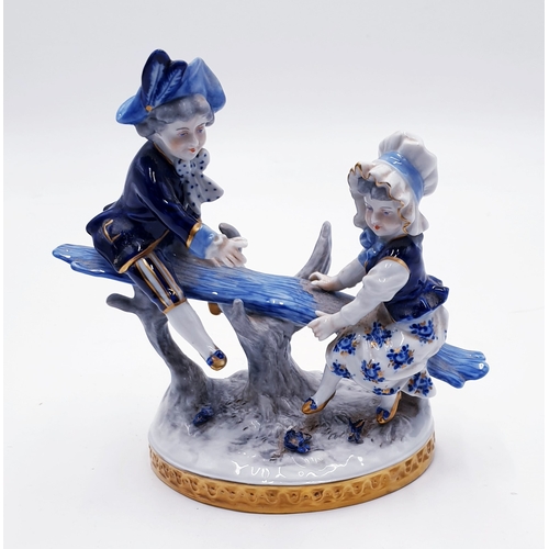 392 - VOLKSTEDTH PORCELAIN 17cm BLUE/WHITE FIGURINE OF A BOY And GIRL ON A TREE BENCH/SWING c1950s / 60s