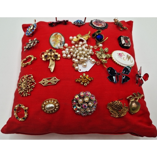 24 - CUSHION CONTAINING 25 ASSORTED BROOCHES