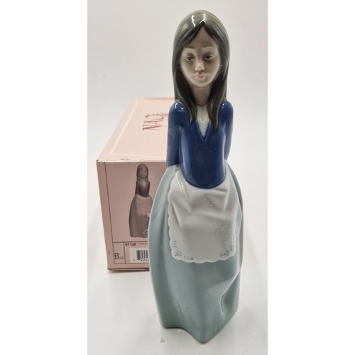 52 - LLADRO (Nao) PORCELAIN 20cm CHARACTER FIGURINE OF A YOUNG GIRL WEARING AN APRON WITH HER HANDS BEHIN... 