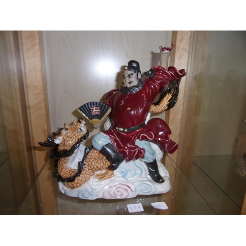 377 - A moulded Chinese Shiwan figure of an Immortal sitting on a dragon