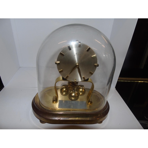 33 - A vintage West German brass mantle clock under a glass dome