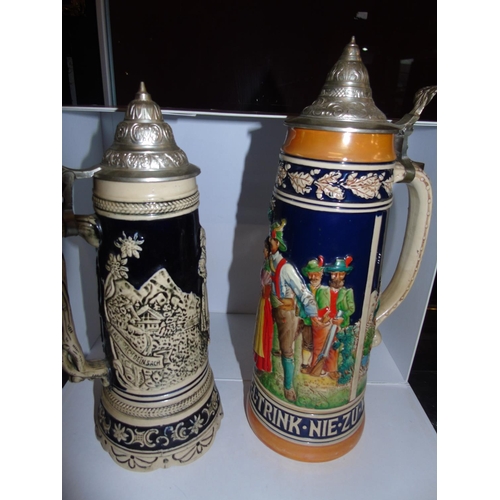 23 - Two large vintage German pottery musical beer steins. 38cm & 34cm tall