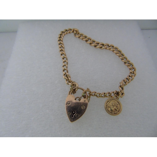 562 - A heavy 9ct rose gold heart lock charm bracelet