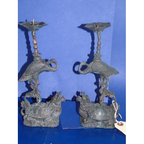 36 - A pair of quality Chinese bronze candlesticks in the form of storks mounted on dragons 23cm tall