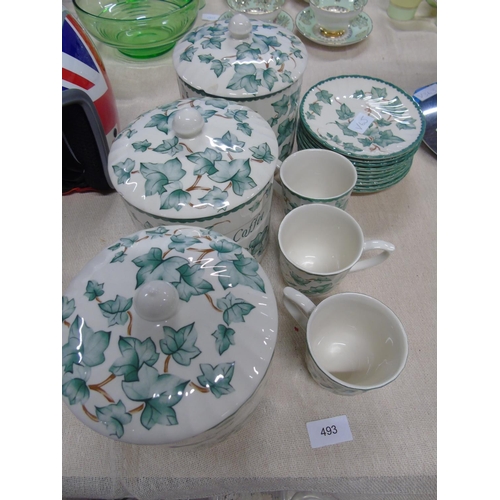 493 - A floral patterned set of kitchen cannisters & cups & saucers