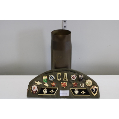 347 - A military cap & badges and a military shell case