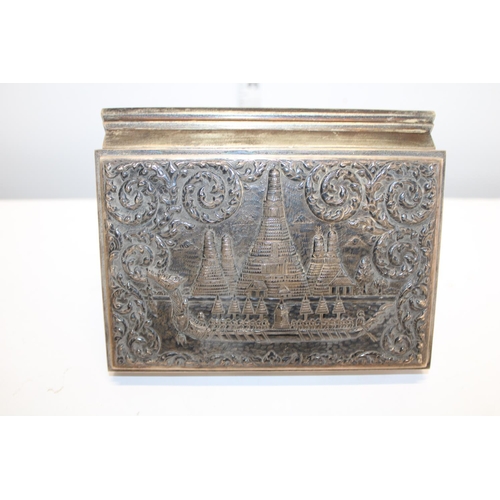 458 - A Sterling silver cigarette box with wooden liner & cover depicting a Thai dragon headed boat