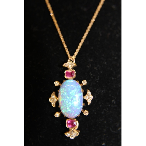 153 - A beautiful 14ct gold pendant and chain with a large central opal flanked by two rubies & diamonds