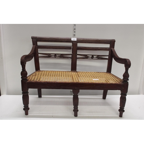 404 - A miniature wooden Bergere wooden and cane bench. Postage unavailable