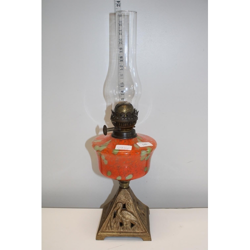 146 - A brass and glass oil lamp with orange and green reservoir