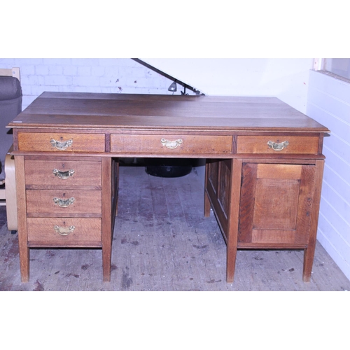 269 - A large oak partners desk with brass fittings. Postage unavailable. 152cm x 106cm x 83cm