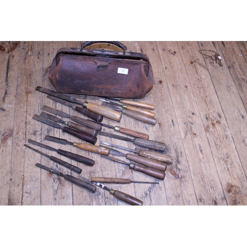 79 - A vintage leather bag full of assorted antique woodworking chisels