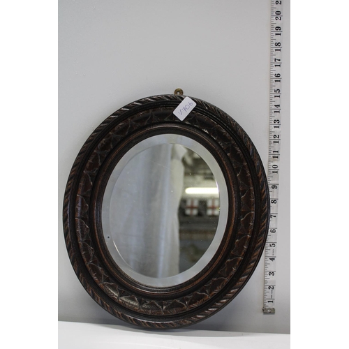 14 - A wooden antique framed oval mirror with bevelled edge glass