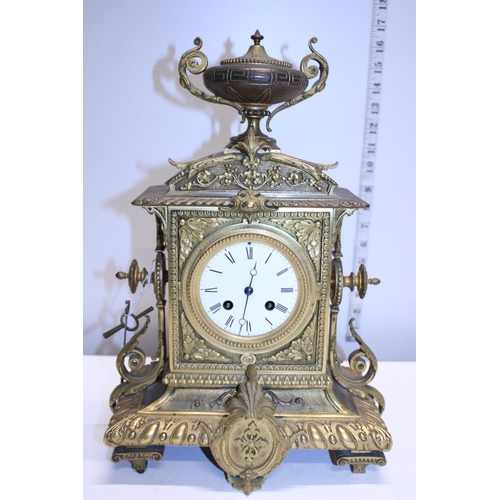 211 - A heavy gilt brass mantle clock with enamel face, with key and pendulum. Shipping unavailable