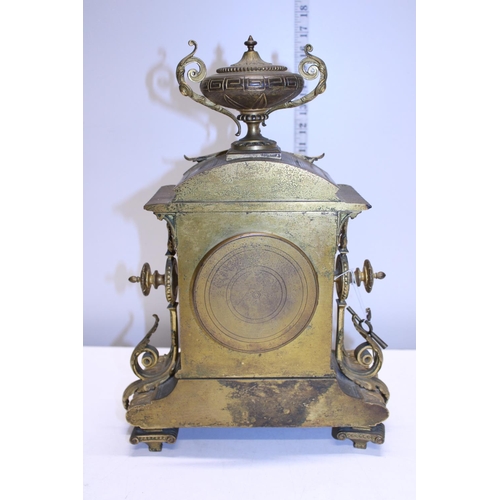 211 - A heavy gilt brass mantle clock with enamel face, with key and pendulum. Shipping unavailable