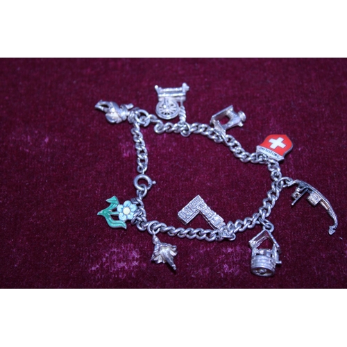 261 - A white metal bracelet with silver charms