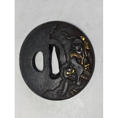 219 - A 18th century Japanese iron Tsuba sword guard with gilt decoration