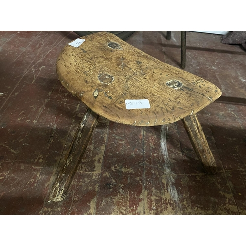 65 - A antique three legged wooden stool.