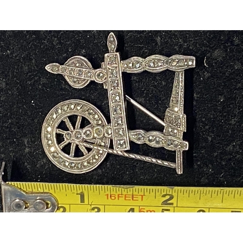 122 - A silver and marcasite brooch in the form of a spinning wheel