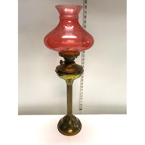 71 - A antique oil lamp with brass column and Cranberry shade h67cm, shipping unavailable