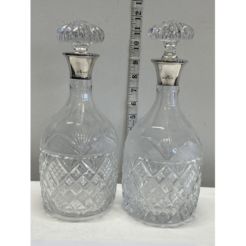 385 - A near pair of quality cut glass decanters with hallmarked silver collars