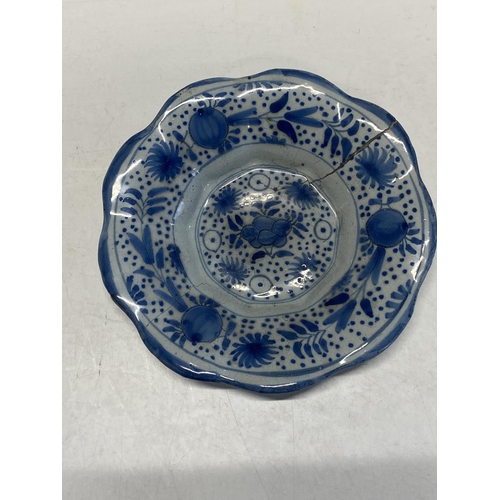 173 - A 17th century delf blue and white lobed dish with fruit decoration (has large crack)