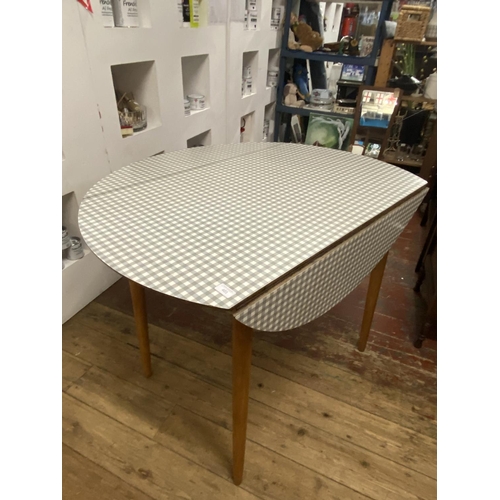 359 - A mid-century Kandja dining table with two drop leaves and checkered formica top, shipping unavailab... 