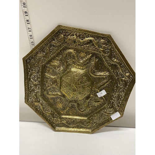 38 - A large hexagonal form brass plaque with dragon form decoration d43cm