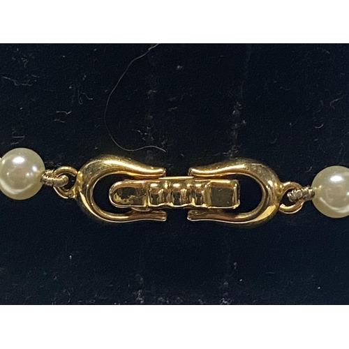 332 - A string of simulated pearls with 14ct gold fittings