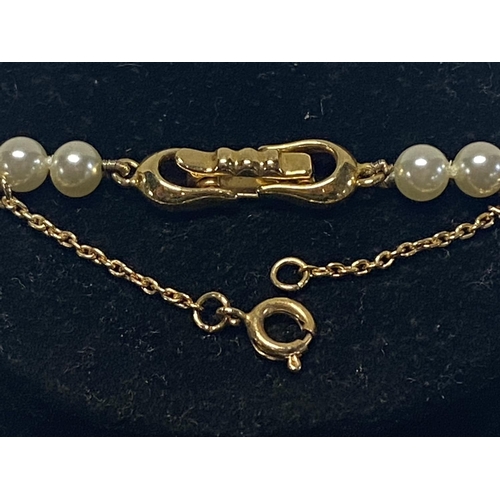 332 - A string of simulated pearls with 14ct gold fittings